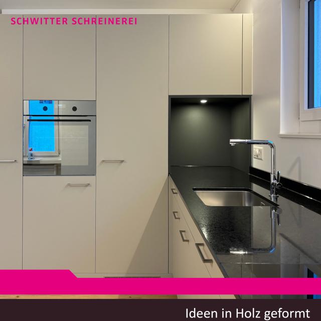 Küche mit heller Front und schwarzem Granit