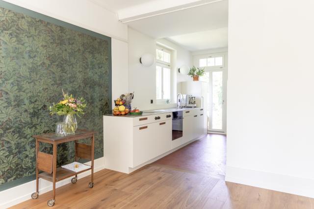 Küchenumbau in Aarau - weisse Küche mit ausgefrästen Griffmulden und Chromstahlabdeckung