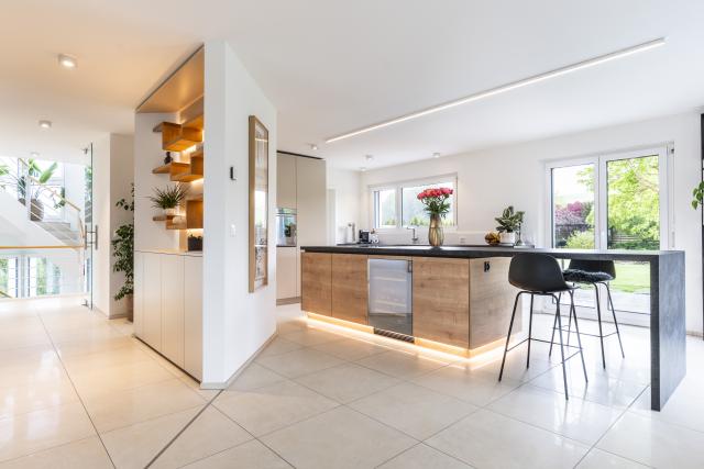 Wohnküche mit hinterleuchtetem Regal und Bartisch