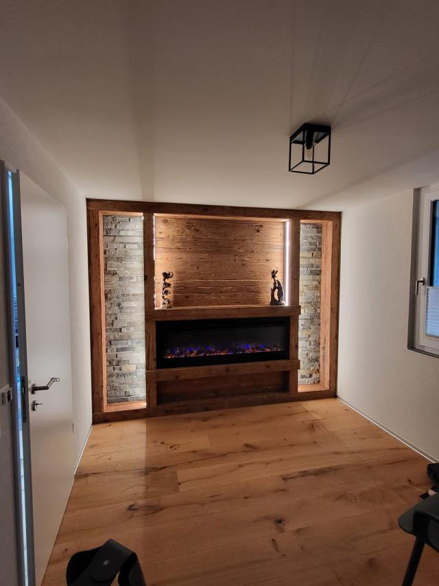 Wandverkleidung in Altholz, mit Elektro Cheminée und LED Beleuchtung.